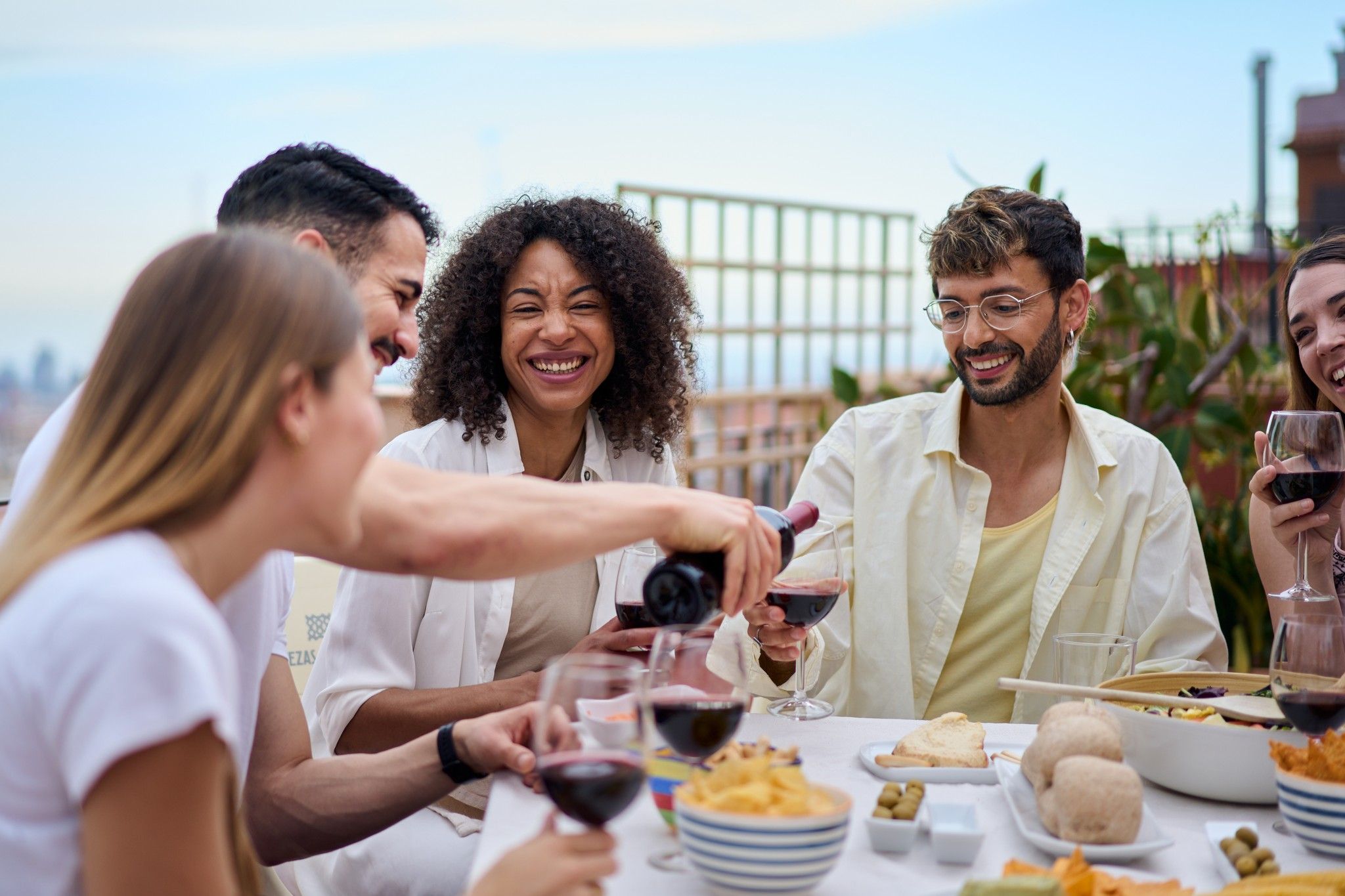 Young folks having dinner and wine on a rooftop