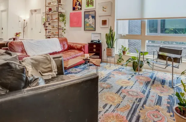 OSLO Co-Living living room furnished with a couch, chairs, and indoor plants