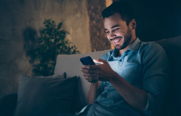 Young man using a cell phone at night