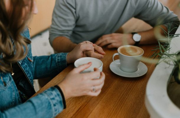 Two people sitting at a table drinking coffee