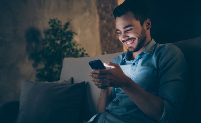 Young man using a cell phone at night